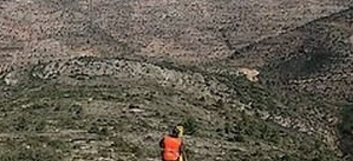 Bashar Masri wearing an orange safety vest while surveying the hilly Rawabi City development site