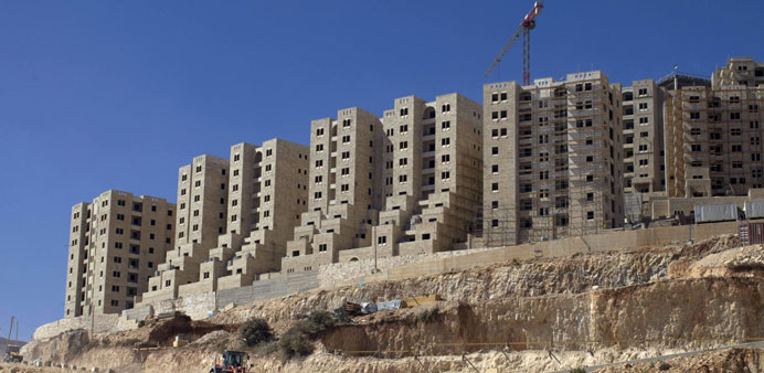 Multi-storey residential buildings under construction on a hillside in Rawabi City