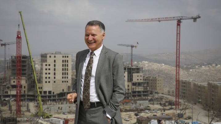 Bashar Masri standing in front of buildings and construction cranes at Rawabi City