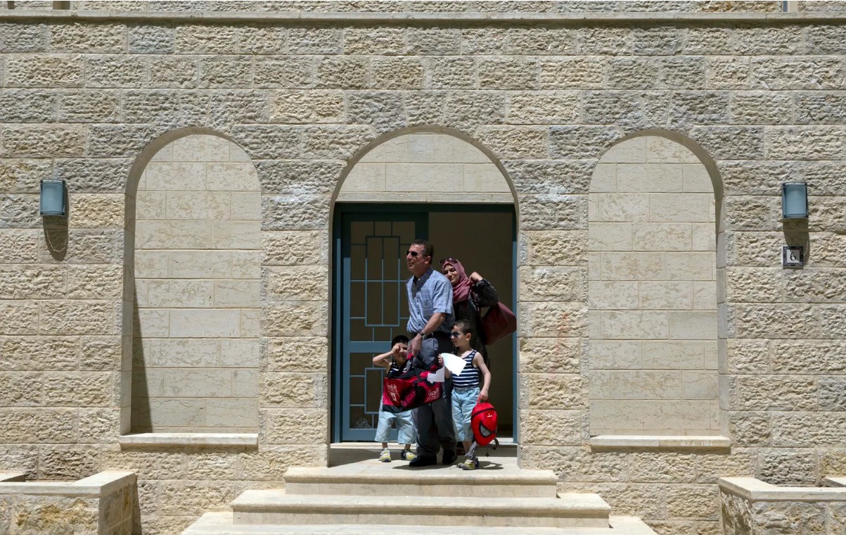 A Palestinian family leaves their newly delivered apartment in the West Bank city of Rawabi, north of Ramallah, June 4, 2016